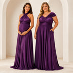 color:Grape |Two women modeling floor-length purple dresses in a bright, minimalist interior with white arches. The dress on the left is a halter-neck maternity gown with a draped bodice and flowing skirt.